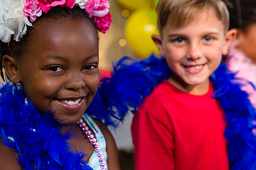 Portrait of children with feather boa during birthday party