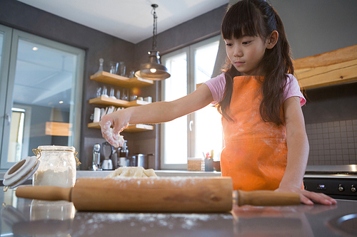 Girl preparing dough in kitchen at home