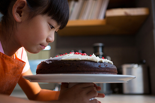 Cake looking at cream cake in kitchen