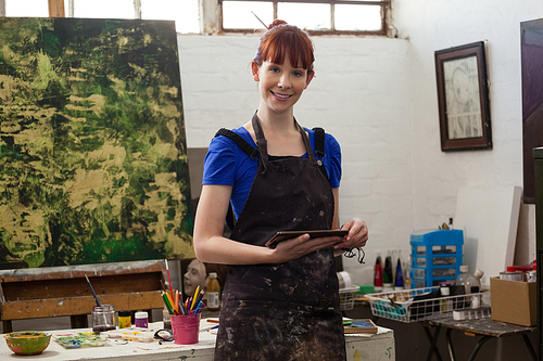 Portrait of beautiful woman holding digital tablet in class