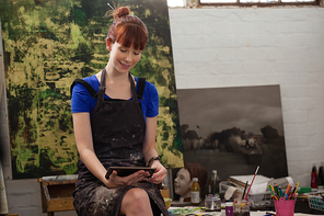 Beautiful woman using digital tablet at table