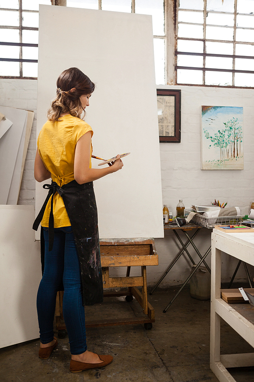 Woman painting on canvas in drawing class