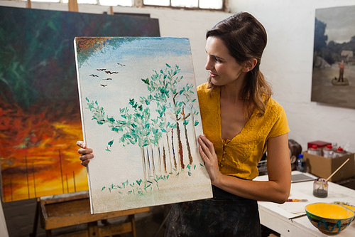Woman holding a painting in drawing class