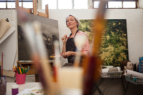 Woman painting on canvas in drawing class