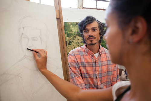 Woman shading a sketch in canvas at drawing class