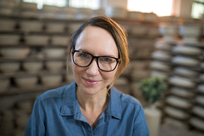 Portrait of happy female potter in pottery shop