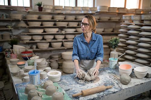 Female potter molding a clay in pottery shop