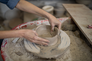 Close-up of female potter molding clay in pottery workshop