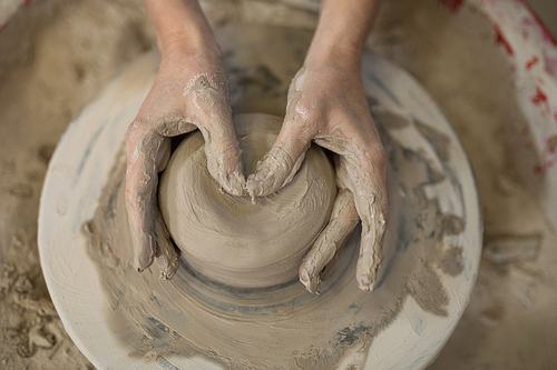 Close-up of female potter molding clay in pottery workshop