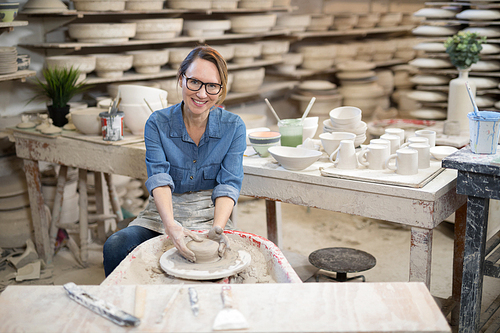 Portrait of female potter molding a clay in pottery workshop