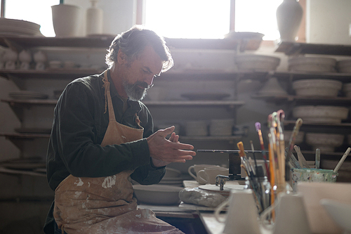 Male potter molding a clay in pottery workshop