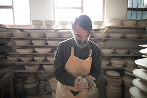 Male potter molding a clay in pottery workshop