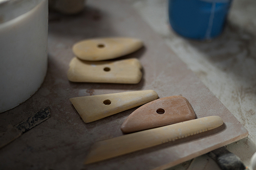 Close-up of work tools on worktop in pottery workshop