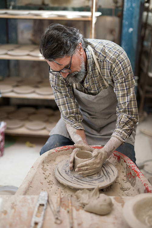 Male potter molding clay in pottery workshop