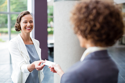 Business executives exchanging business card at conference centre