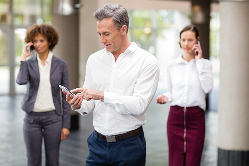 Business executive using mobile phone at conference centre