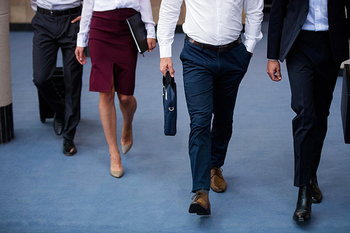Low section of business executives walking in a conference center lobby