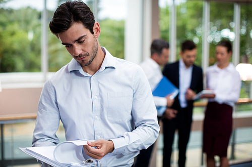 Male business executive looking at document in conference center