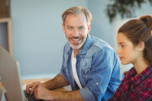 Male executive using laptop in office