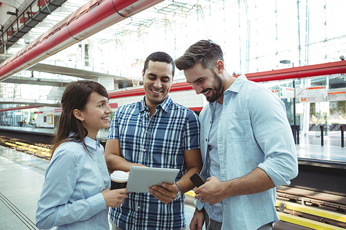 Executives using digital tablet on platform