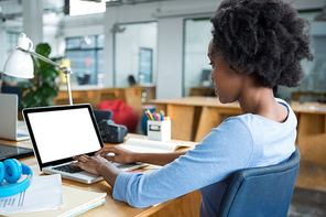 Female graphic designer using laptop in creative office