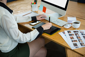 Female graphic designer working at desk in creative office