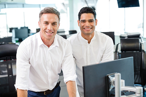 Portrait of smiling business colleagues working at desk in office