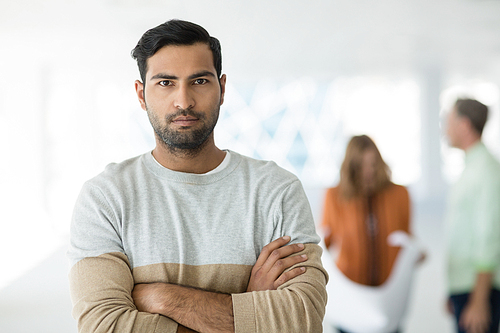 Portrait of business executive standing with arms crossed in office