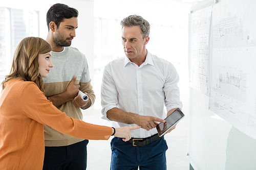 Business colleagues discussing over digital tablet in office