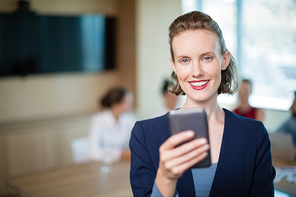 Portrait of beautiful business executive talking on her mobile phone in conference room