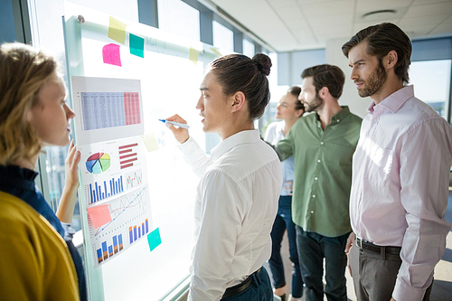 Group of business executives looking at white board in office