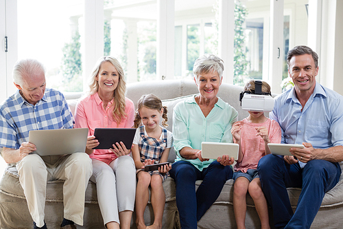 Multi-generation family using digital tablet, mobile phone and virtual headset in living room at home