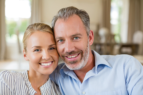 Portrait of romantic couple smiling in living room at home