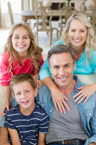 Portrait of smiling parents and kids in living room at home