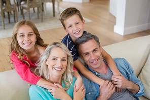 Portrait of smiling parents and kids in living room at home