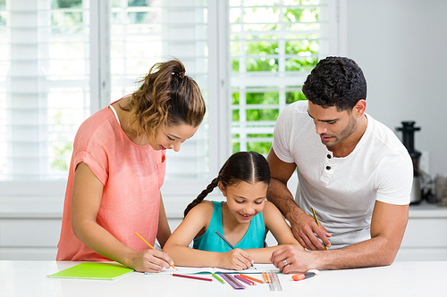 Smiling parents and daughter drawing in kitchen at home