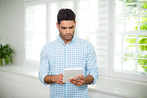 Man using digital tablet in living room at home