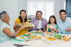 Portrait of happy multi generation family having meal on table at home