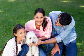 Happy family enjoying together with their pet dog in park