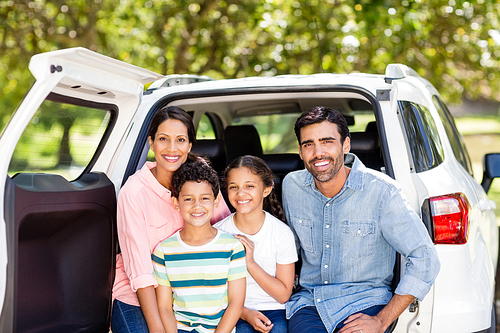 Portrait of happy family sitting in car in park