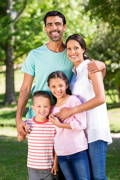 Portrait of happy family standing in park on a sunny day
