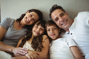 Portrait of parents and kids sitting on the bed