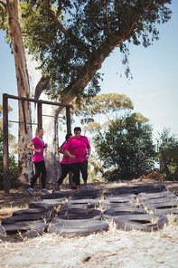 Group of women practicing tyres obstacle course in the boot camp