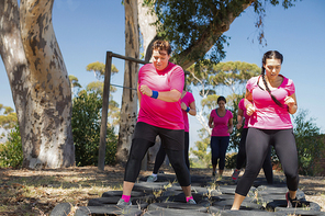 Group of women practicing tyres obstacle course in the boot camp