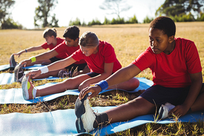 Group of kids exercising in the boot camp on a sunny day