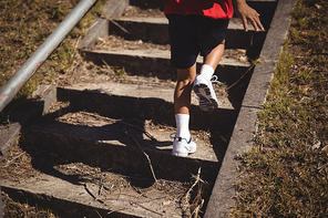 Low section of girl running upstairs during obstacle course in boot camp