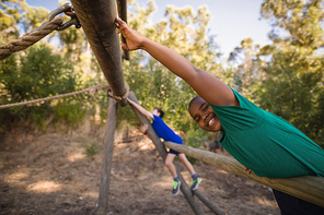 Portrait of happy boy exercising on outdoor equipment during obstacle course in boot camp