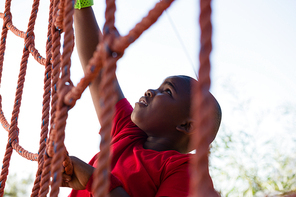 Boy climbing a net during obstacle course training in the boot camp