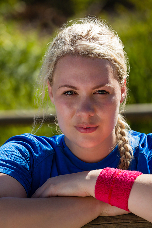 Portrait of fit woman leaning on hurdles during obstacle course training in the boot camp