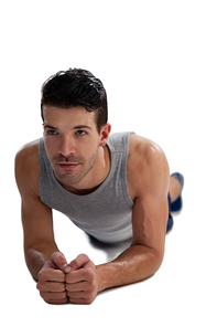 Determined sports player exercising planks against white background